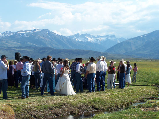 outdoor wedding party in front of snow-capped mountains