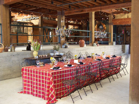 red check tablecloth on long table inside a barn