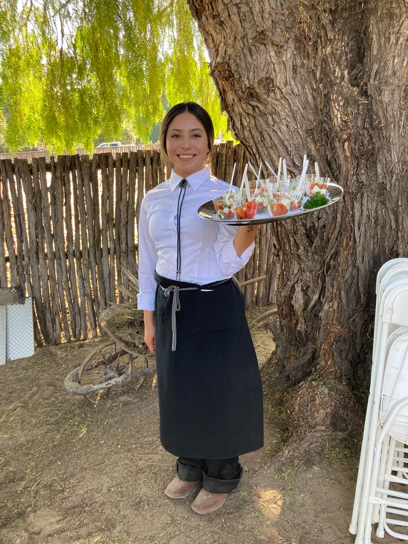 smiling server holding a tray of appetizers